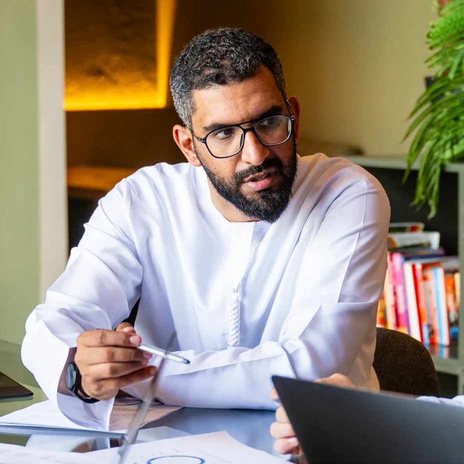 A business leader reviewing plans at his desk